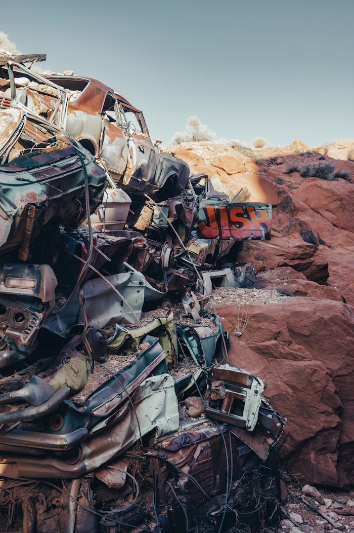 A dramatic view of stacked car wrecks in a desert junkyard, highlighting decay and abandonment.