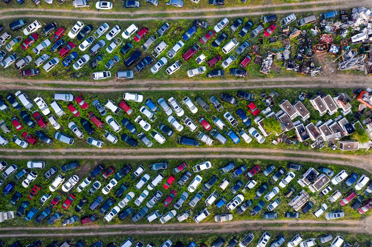 Services Top view of a busy scrapyard in Saint Charles filled with rows of abandoned vehicles and metal parts.